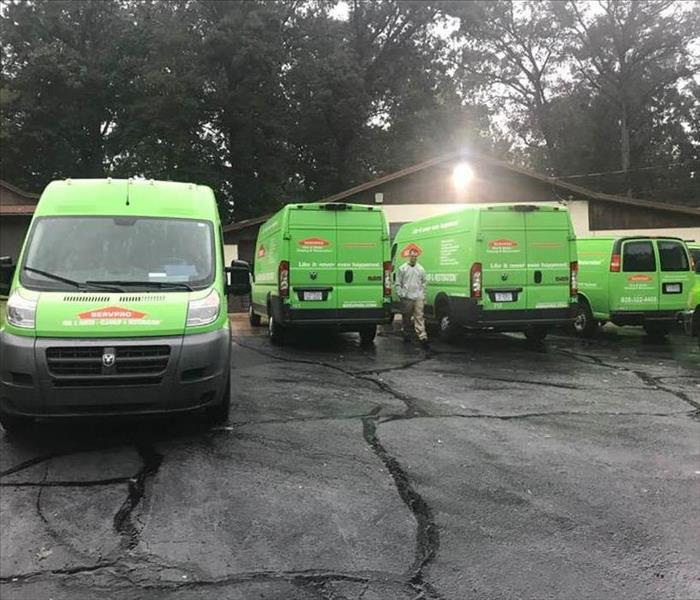SERVPRO vehicles lined up on wet under a dark, cloudy sky
