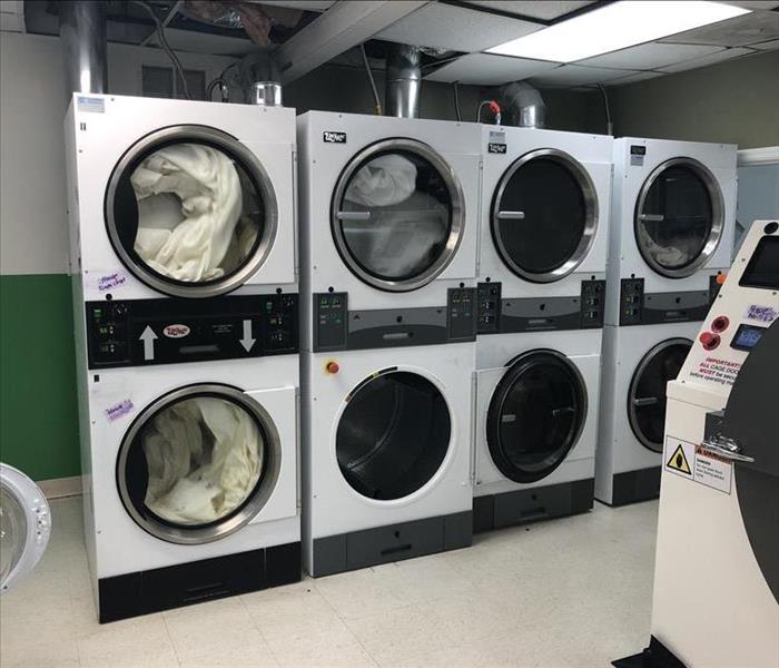 Stacked, white washing machines lined in a row
