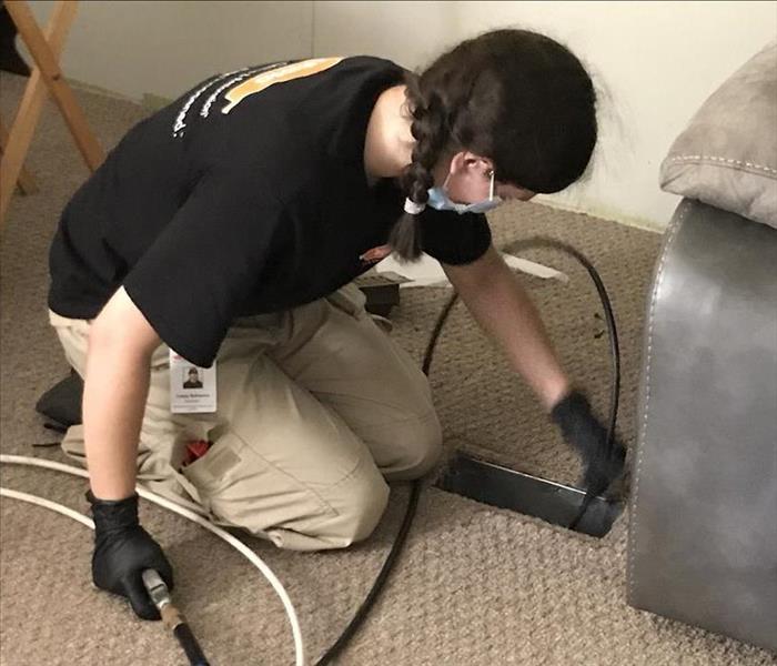 Female SERVPRO employee cleaning floor vent